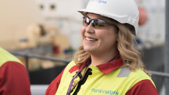 Close-up of female National Grid engineer wearing a hard hat and high-vis vest